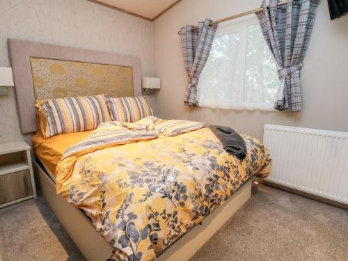 a bedroom with a bed and a window at 13 Harlech Court in Prestatyn