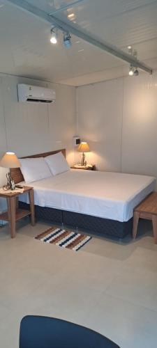 ein großes Bett in einem Zimmer mit 2 Tischen in der Unterkunft Mirador las Colinas in Paraguarí