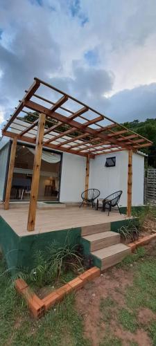 ein Haus mit einer Holzterrasse mit einem Dach in der Unterkunft Mirador las Colinas in Paraguarí