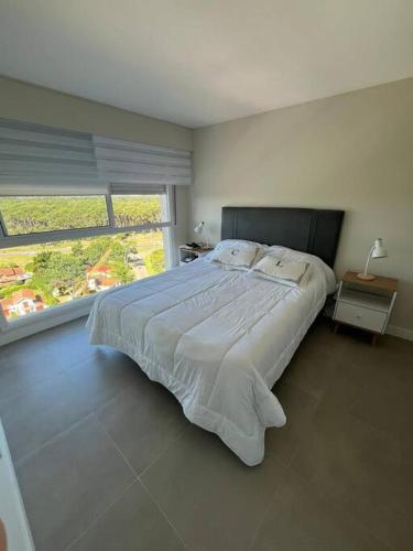 a bedroom with a large bed and a large window at Alquiler Apto Punta Del Este in Punta del Este