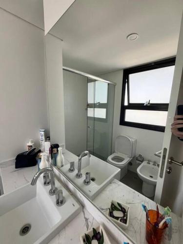 a white bathroom with two sinks and a toilet at Alquiler Apto Punta Del Este in Punta del Este