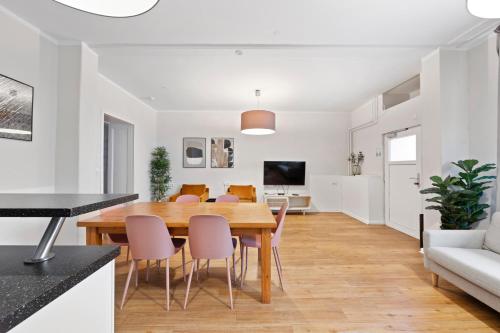 a dining room and living room with a wooden table and chairs at primeflats - Big family apartment Schöneberg in Berlin