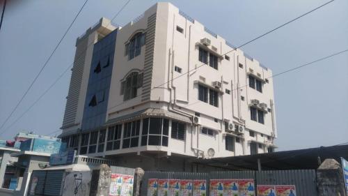 a white building with a fence in front of it at HOTEL OASIS PALACE in Dālkola