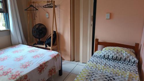 a bedroom with a bed and a fan next to a window at Pousada e Camping da Rhaiana - Ilha do Mel - PR in Ilha do Mel