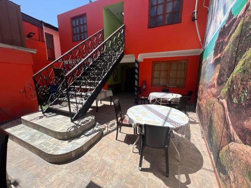 a building with stairs and a table in front of it at Hotel Casa del profesor Iquique in Iquique