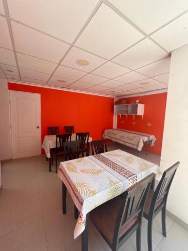 a dining room with red walls and tables and chairs at Hotel Casa del profesor Iquique in Iquique