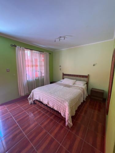 1 dormitorio con 1 cama y suelo de madera en Hotel Casa del profesor Iquique, en Iquique