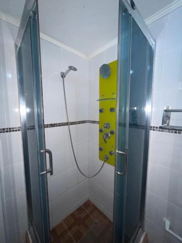 y baño con ducha y puerta de cristal. en Hotel Casa del profesor Iquique, en Iquique
