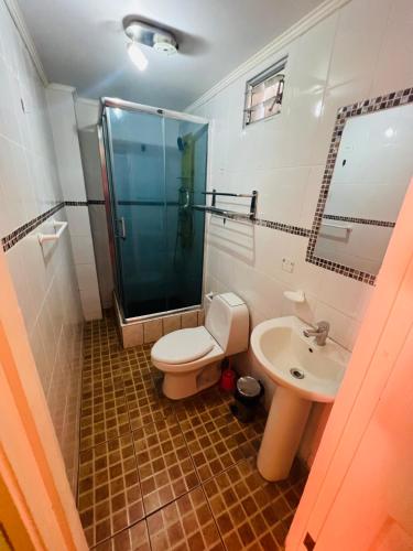 a bathroom with a toilet and a shower and a sink at Hotel Casa del profesor Iquique in Iquique