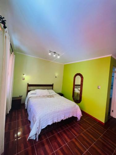 a bedroom with a bed and a yellow wall at Hotel Casa del profesor Iquique in Iquique