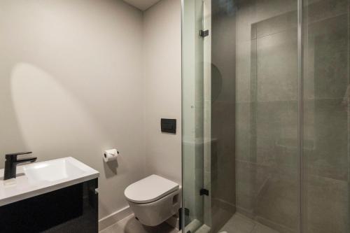 a bathroom with a shower and a toilet and a sink at 001 The Tokyo in Cape Town