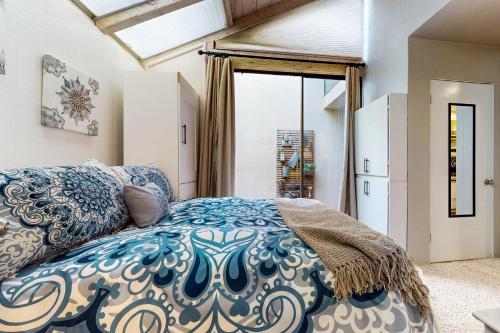 a bedroom with a blue and white bed and a window at Anchor's Rest in Carmel