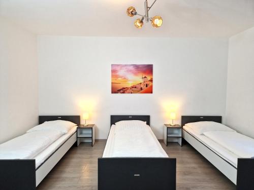 two beds in a room with two lamps and a painting on the wall at Meribu G31 Wohnung für Monteure und Arbeiter in Essen