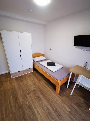 a small room with a bed and a table at Landhaus Herdt in Lauda-Königshofen