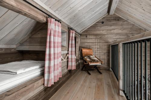 a room with a bed and a chair in a attic at Luxurious cottage with sauna overlooking mountains in Vemdalsskalet