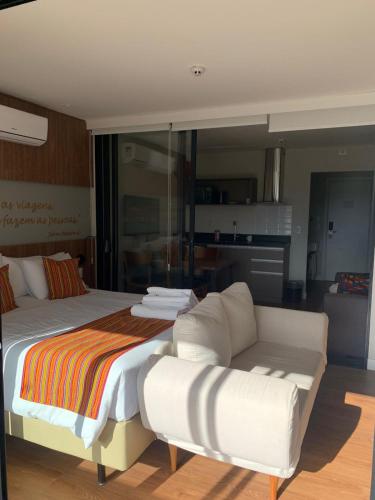 a bedroom with a large bed and a couch at Wanderlust Experience Hotel BW Signature - Campos do Jordão in Campos do Jordão