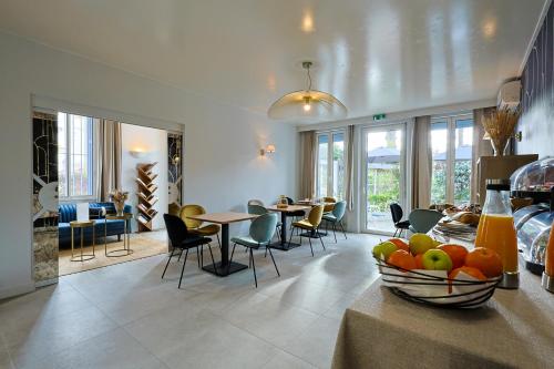 a living room with tables and chairs and a bowl of fruit at Hotel Albert 1er in Cannes