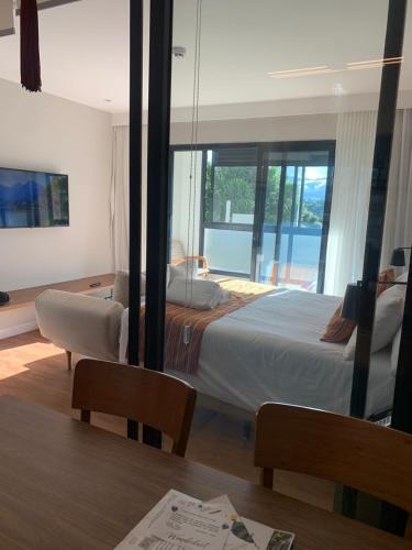 a hotel room with a bed and a dining table at Wanderlust Experience Hotel BW Signature - Campos do Jordão in Campos do Jordão