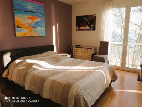 une chambre avec un lit et un tableau au mur dans l'établissement Appartement de 3 chambres face à la mer, à Saint-Nazaire