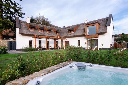 a house with a hot tub in front of it at Pipitér Rooms & More in Szigliget