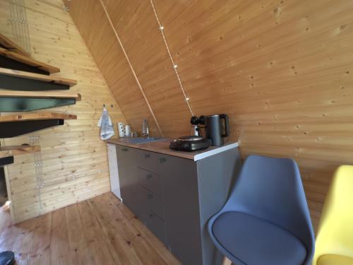 una pequeña cocina con una silla azul en una cabaña en Focus Point Drakhtik - Green Cabin en Drakhtik