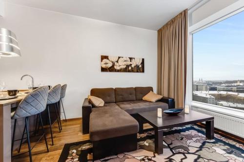 un soggiorno con divano e tavolo di High-Rise Amazing View Apartment 14th Floor In CityCentre a Tallinn
