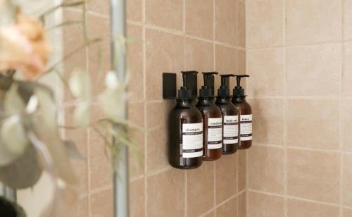 a group of four bottles of oils in a shower at Cozy Artist's Cottage-3br, Dt, Uga, Classic Cent in Athens