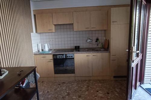 a small kitchen with wooden cabinets and a sink at Ferienwohnung Dallmann in Niestetal