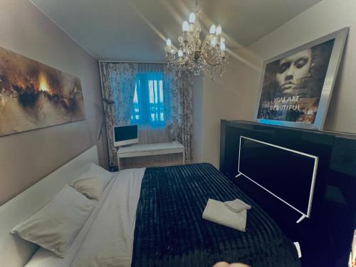sypialnia z łóżkiem i żyrandolem w obiekcie Chambre Confortable disponible à Genève w Genewie