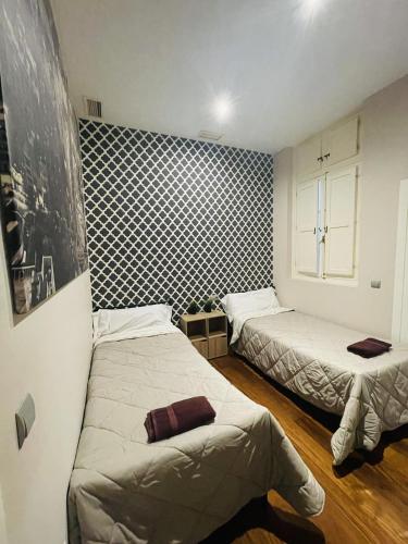 1 dormitorio con 2 camas y ventana. en 7Seven Apartament, en Málaga