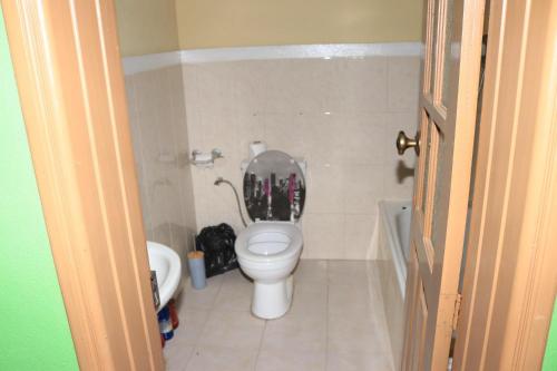a small bathroom with a toilet with a lid at Ramos Aparttment in São Filipe