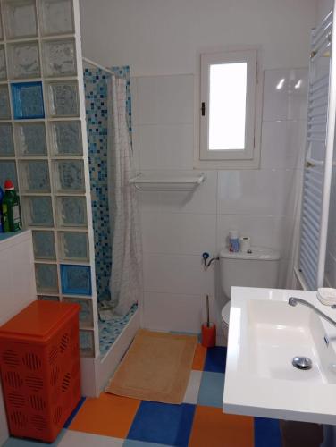 a bathroom with a sink and a toilet and a window at La playa in L'Escala