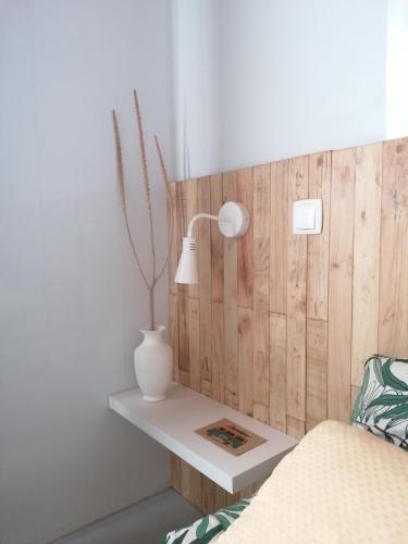 a white lamp on a white table in a bedroom at Kanela Guest House in Machico