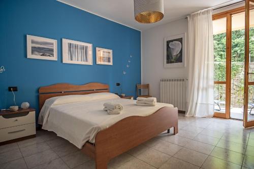 Un dormitorio azul con una cama con toallas. en The River Nest, en Lasnigo
