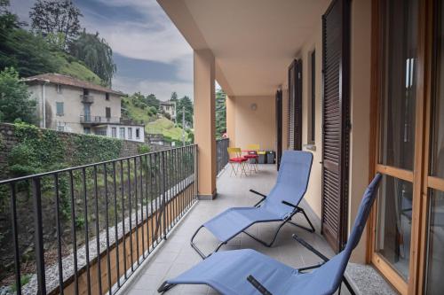 2 sillas azules en un balcón con vistas en The River Nest, en Lasnigo