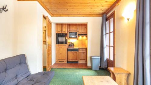 un salon avec un canapé et une cuisine dans l'établissement Alpina Lodge 23 - Appt pied des pistes 6 pers, à Les Deux Alpes
