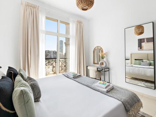 um quarto branco com uma cama grande e uma janela em Stunning and Brand New La Fontana 513 no Dubai