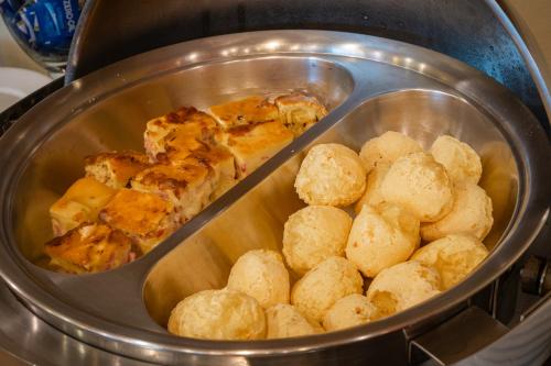 a pan with some food in a stove at Carlton Plaza São José dos Campos in São José dos Campos