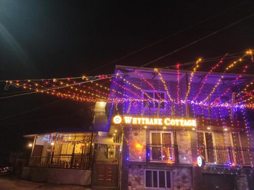 a building with christmas lights on it at night at Whyt Bank Cottage Comfort Stays in Mussoorie