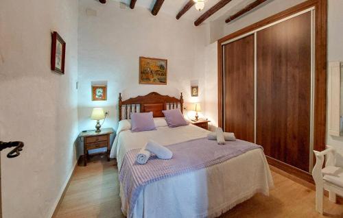 1 dormitorio con 1 cama grande con almohadas moradas en Cozy Home In Benalaureia With Kitchen, en Benalauría