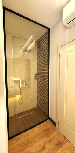 a bathroom with a shower with a glass door at Tirana Central Rooms in Tirana