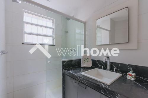 a bathroom with a sink and a mirror at Charmoso apartamento a 550m da Praia do Flamengo in Rio de Janeiro