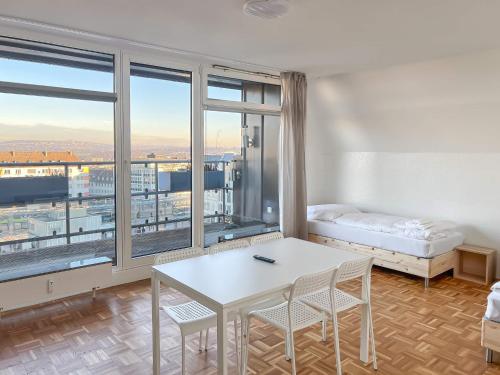 Cette chambre dispose d'une grande fenêtre et d'une table avec des chaises. dans l'établissement T&K Apartments - 2 and 3 Room Apartments - Heart of Solingen-Hofgarten, à Solingen