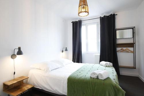 ein Schlafzimmer mit einem Bett mit zwei gefalteten Handtüchern darauf in der Unterkunft Maison VIOGNIER in Condrieu