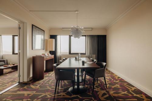 a dining room with a table and chairs in a room at Leonardo Hotel Den Haag Babylon in The Hague