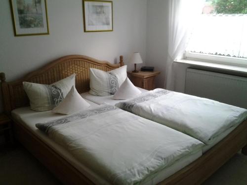 - une chambre avec 2 lits avec des draps blancs et une fenêtre dans l'établissement Ferienwohnung Christa Hahn, à Birkenau