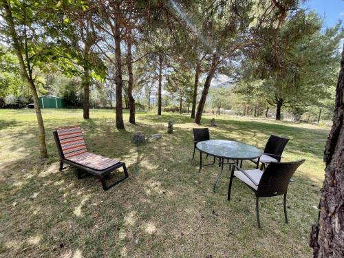 een tafel en stoelen in een park met bomen bij Chalet del Roble in Biescas