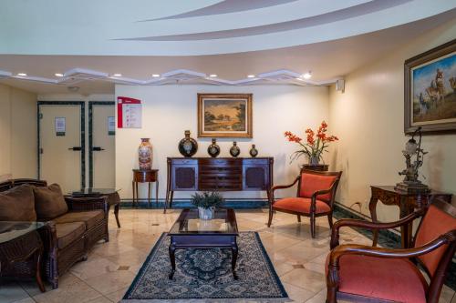 a living room with a couch and a fireplace at Carlton Plaza São José dos Campos in São José dos Campos