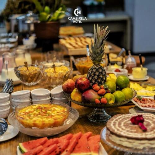 a table topped with lots of different types of food at Cambirela Hotel in Florianópolis