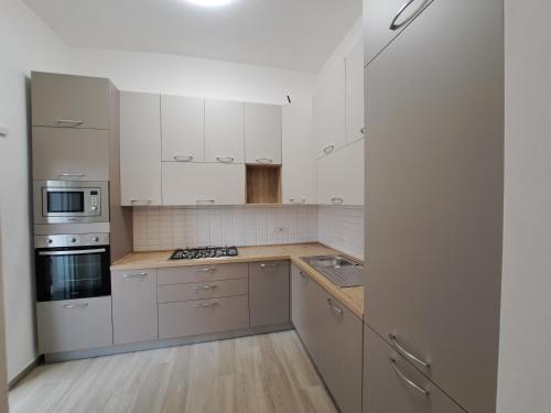 a kitchen with white cabinets and a stove top oven at Le Scalette in Minturno